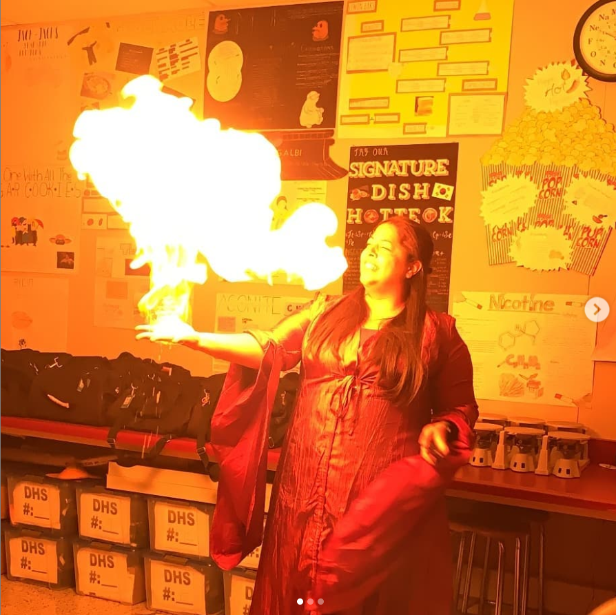 Ms Lara in her Game of Thrones costume lights her hand on fire in a demonstration of a chemical reaction 