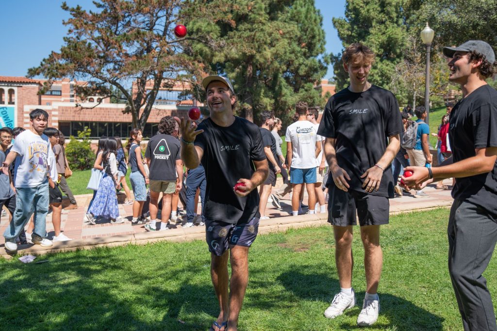 Second-year students try out their juggling skills with equipment provided by the Juggling Club at UCLA by the side of Janss Steps while other students look on. Many clubs show off their expertise at the fair to attract interested individuals. Photo by Julia Gu/BruinLife.