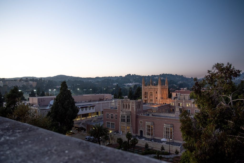 The north side of the Mathematical Sciences roof offers a sprawling view of campus from above. Part of this view is Kerckhoff Hall and Ackerman Union, as lit by warm evening lights. Photographed by Julia Gu/BruinLife.