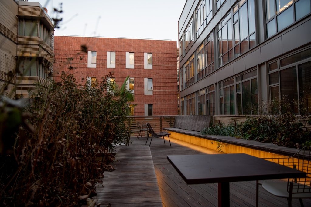 In the evenings, lights illuminate the Engineering VI patio and a cool breeze blows through the leaves. Many offices stay lit as the day slowly draws to a close. Photographed by Julia Gu/BruinLife.