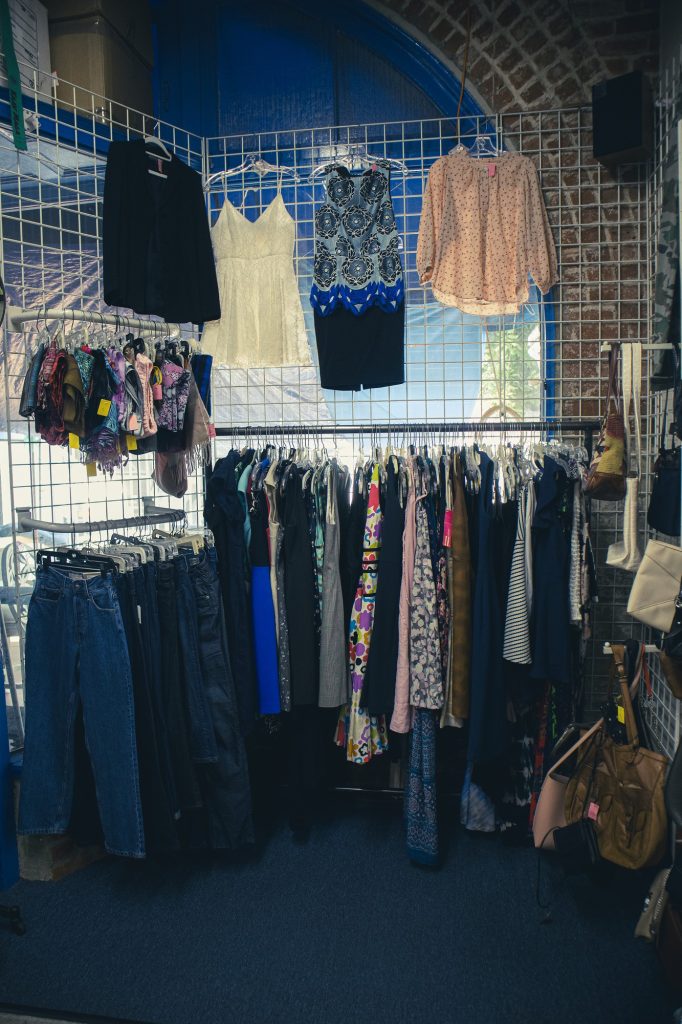 Miscellaneous clothes pieces are featured on a wire wall inside the store. The UCLA Thrift Shop sells more than just UCLA gear, offering a large amount of wearables for adults and children of all sizes.