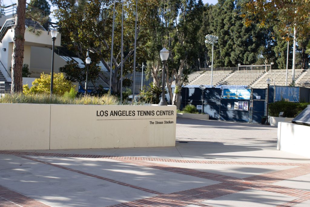 The words "Los Angeles Tennis Center," displayed on a short wall near the tennis courts, serve as a guide at the entrance of the pathway. Instead of walking up the Hill at the end of the day, cut left at Pauley Pavilion and go through the Los Angeles Tennis Center. This is the same tennis center where UCLA holds its annual Spring Sing and Bruin Bash!