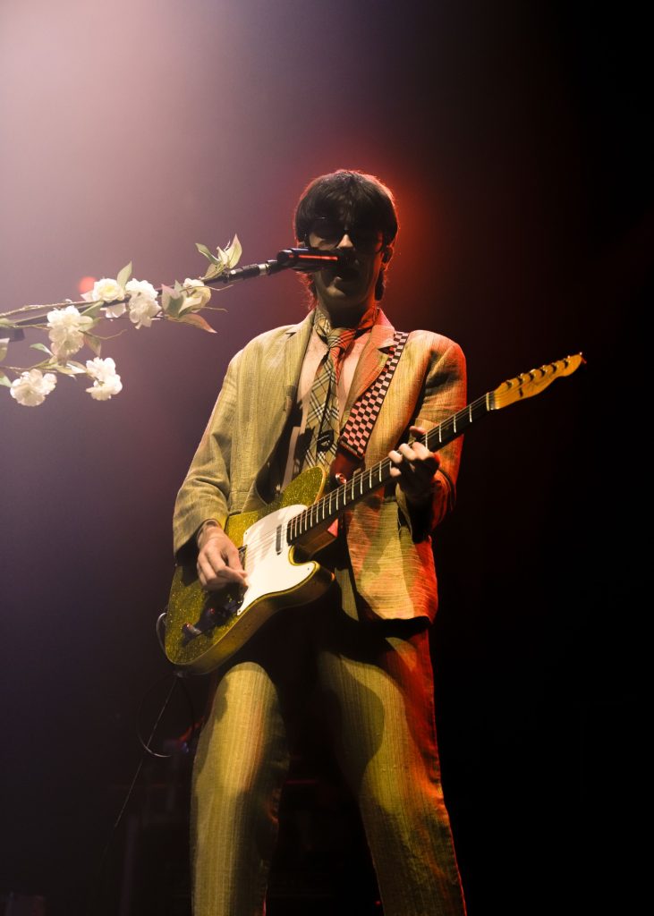 Mckenna performed in a gold-toned suit with his iconic matching gold-accented guitar. This visual look was paired with a beautiful flower-adorned mic stand.