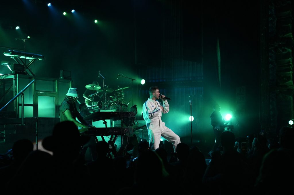 Grammer stands onstage against green stage lights, diving into a mashup of some of his songs. As he filled the room with his immensely powerful vocals, the audience watched in awe as he welcomed an incredible start to the show.