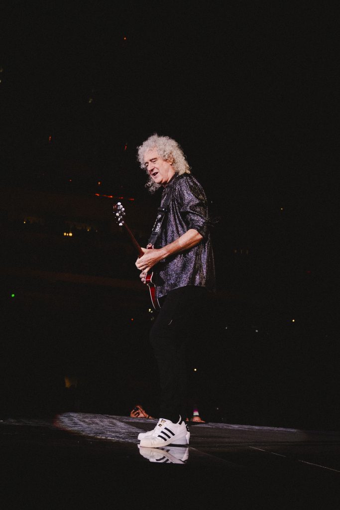Queen's lead Guitarist Brian May performs under the spotlight. He is welcomed by fans at Los Angeles's BMO Stadium.