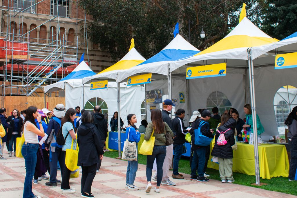 Newly admitted students and their families line up behind information tents along Dickson Plaza.
