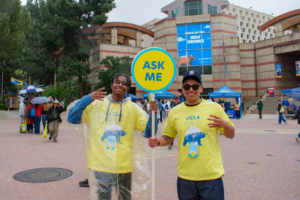 Christian Green (left) and Steven Rodriguez (right), a sophomore studying psychology, pose for the camera in front of UCLA&squot;s "Welcome New Bruins" projection board.