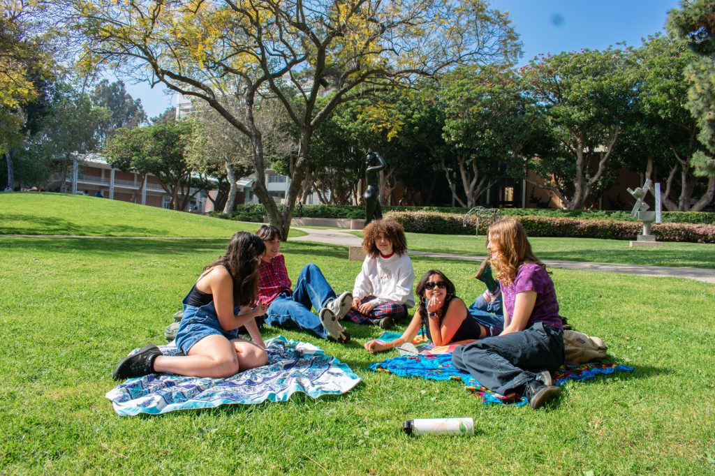 Five students lie on picnic blankets together in the Sculpture Garden. From left to right: Dani Garrido, a second-year psychology student; Aidan Gottdiener-Tan, a second-year student with an undeclared major; Connor Gilbert, a third-year global jazz studies student; Zoe Yee, a second-year student majoring in microbiology, immunology, & molecular genetics and minoring in Asian American studies; and Keira Prouty, a second-year ecology student.