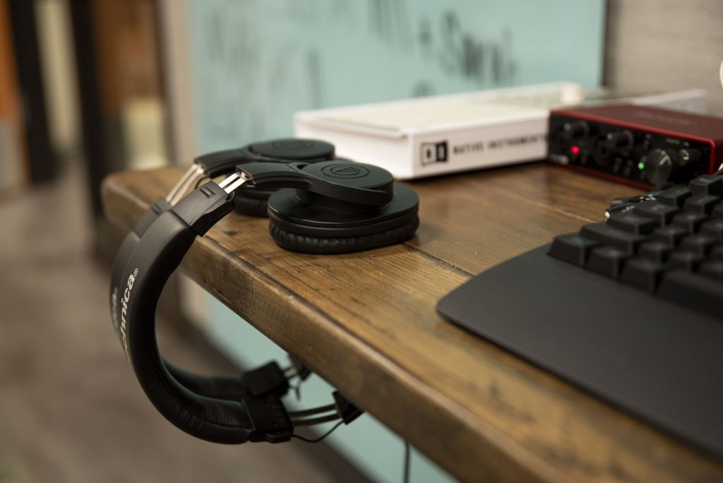 Two headphones rest on a table, with a Maschine Mikro launchpad in the background. Located on the third floor of De Neve Commons, the DeNeve Learning Center is open to all. Photographed by Julia Gu/BruinLife