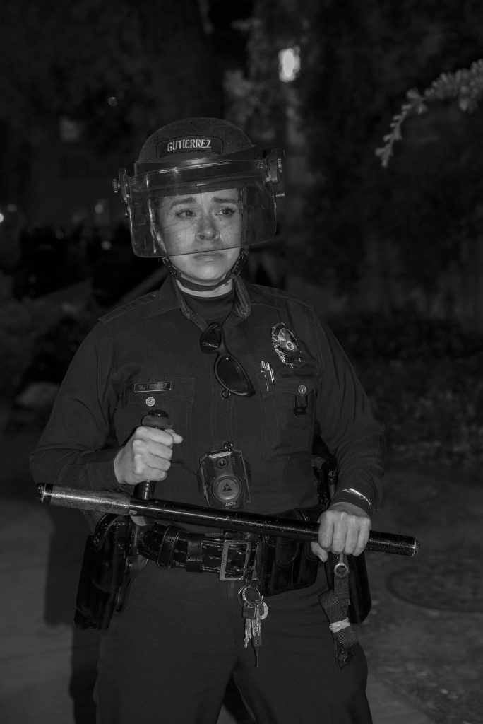 Officer Gutierrez stands with her baton between Royce Hall and Haines Hall. Solidarity protesters who were not inside the encampment were largely kept at a distance from Dickson Plaza, forcefully so. Photographed by Emily Chandler/BruinLife.