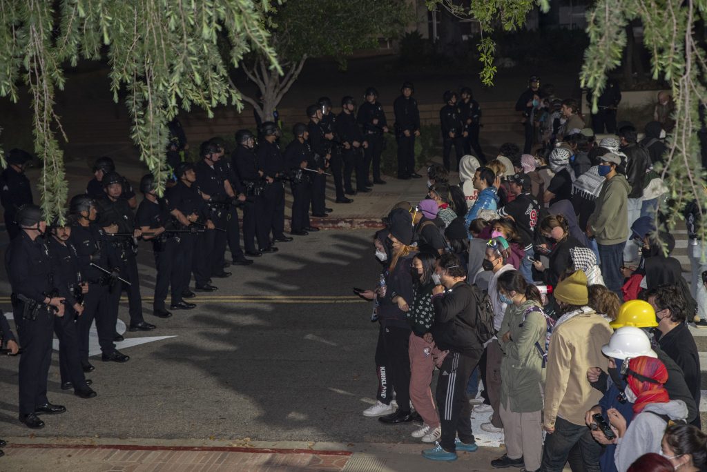 After pushing back the crowd of pro-Palestine protesters on Portola Plaza, law enforcement keeps the crowd back at the corner next to Schoenberg Hall. Photographed by Emily Chandler/BruinLife.