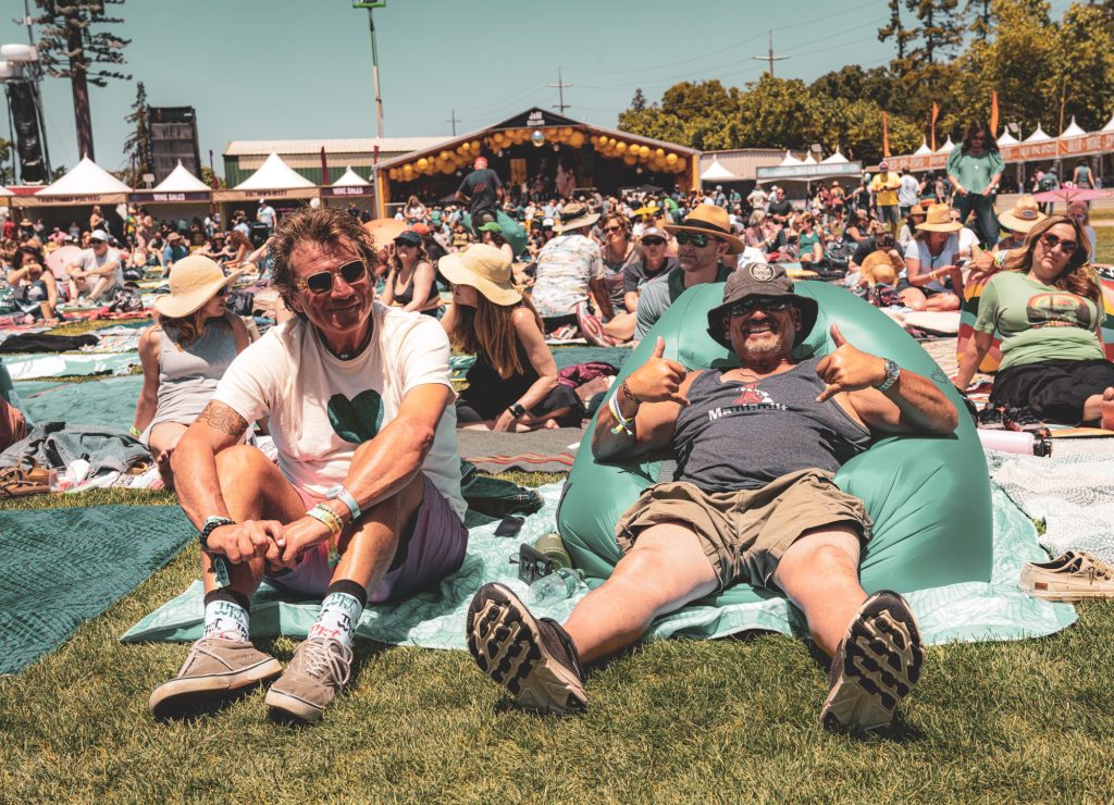 Festivalgoers enjoy a midday rest in the sun while listening to the various performers on the JaM Cellars stage. Photographed by Cathryn Kuczynski/BruinLife