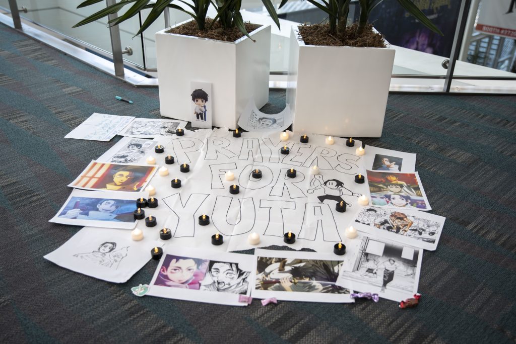 AX attendees set up a shrine with fake candles and printed pictures in a hallway of West Hall reading “Prayers for Yuta.” Yuta is a character from the anime, Jujustu Kaisen. Photographed by Caleb Velasquez/BruinLife.