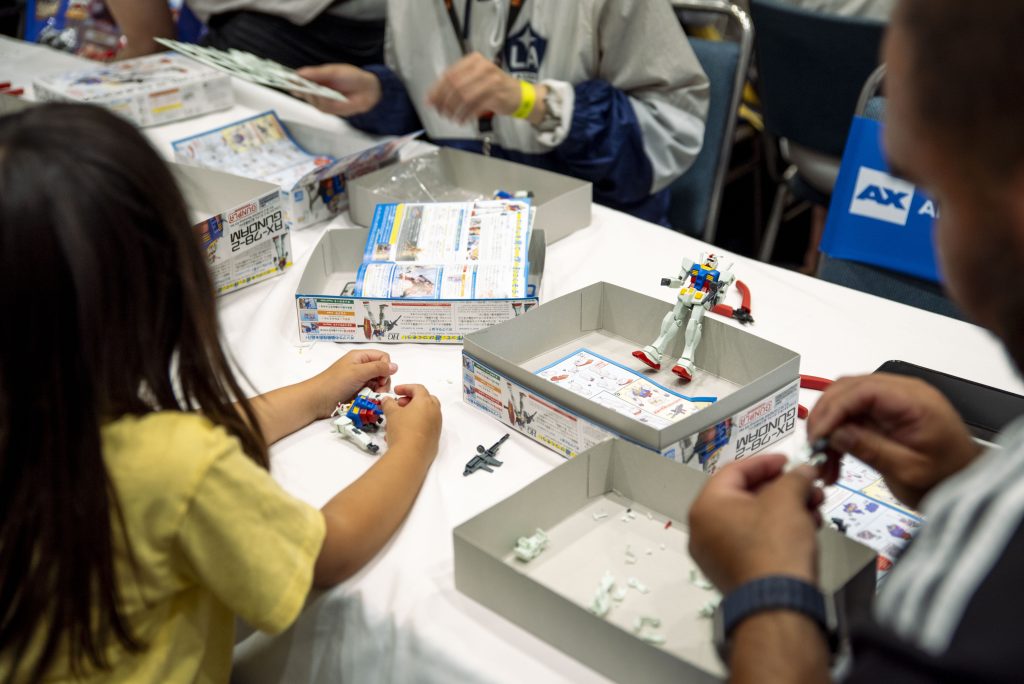 A young attendee constructs her Gunplay during Fridays event. The Gundam Kit Workshop taught attendees how to assemble a Gundam and allowed them to take their model home. Photographed by Emily Chandler/BruinLife.