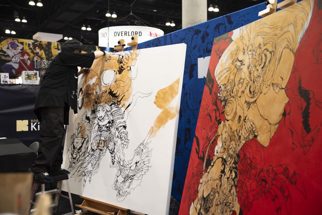 A live art performance by acky_bright on instagram. On Friday, in the Exhibit Hall, this artist spent the day drawing and coloring their work in front of groups of attendees. Photographed by Emily Chandler/BruinLife.