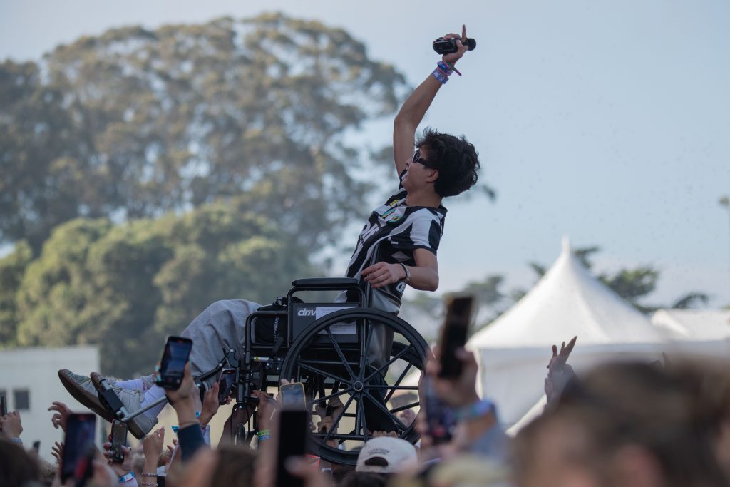 Crowd members lift up a fellow attendee up on a wheelchair as he tries to get a better angle of the performance, eventually catching ScHoolboy Q's attention and being given a shoutout. Photographed by Caleb Velasquez/BruinLife.