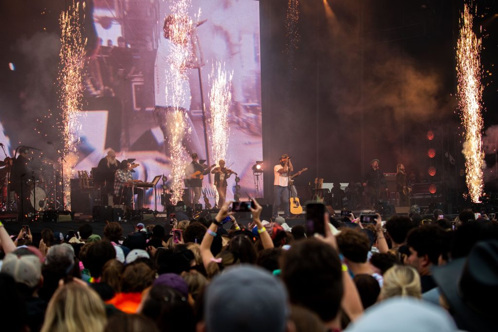 Sparklers and pyrotechnics erupt into the sky as artist Post Malone and his band perform "A Country Boy Can Survive," originally by Hank Williams Jr. Post Malone gave Outside Lanes a special country set, performing many covers and bringing out guest artists along with it. Photographed by Caleb Velasquez/BruinLife.