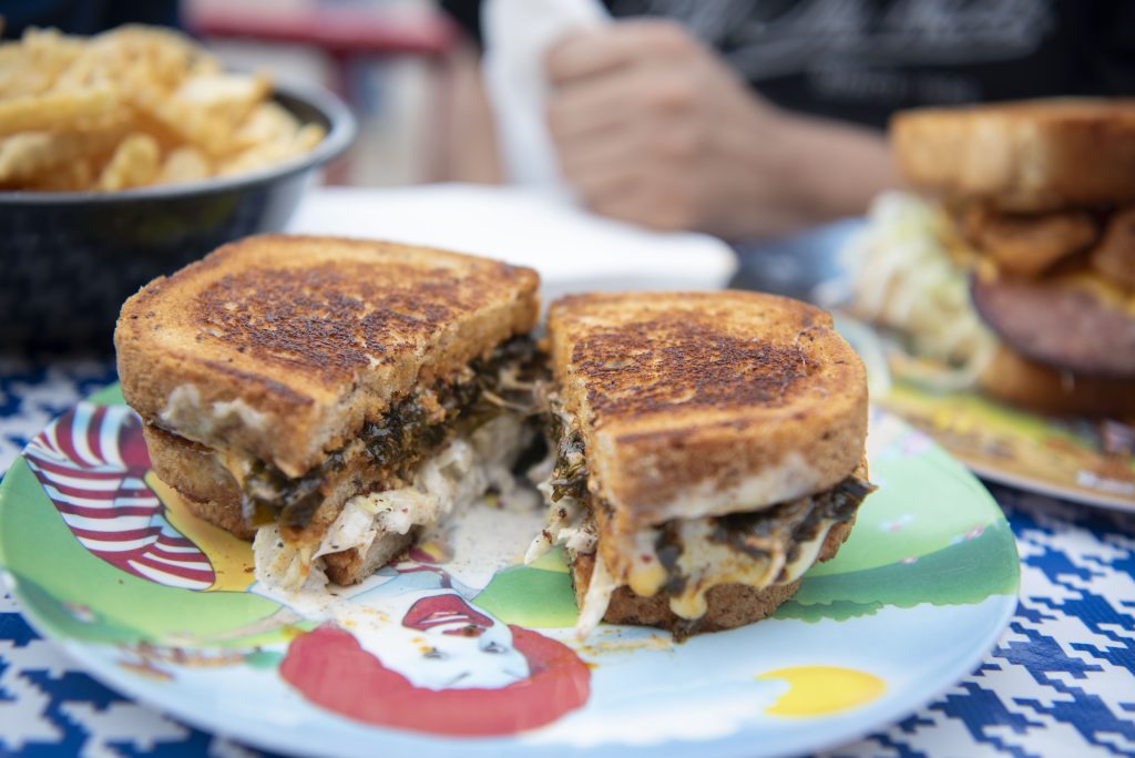 The collard green melt sandwich features toasted bread, spicy mayo, sweet chili-coated collards, creamy cabbage slaw and rich cheese, combining bold flavors and textures. Photographed by Emily Chandler/BruinLife.