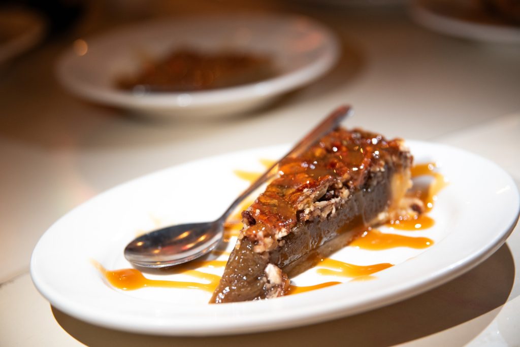 The Creole Pecan Pie rests elegantly on the plate. This dessert is a delicacy that is bound to satisfy any lingering desires from your dinner at Felix's.  Photographed by Finn Martin/BruinLife.