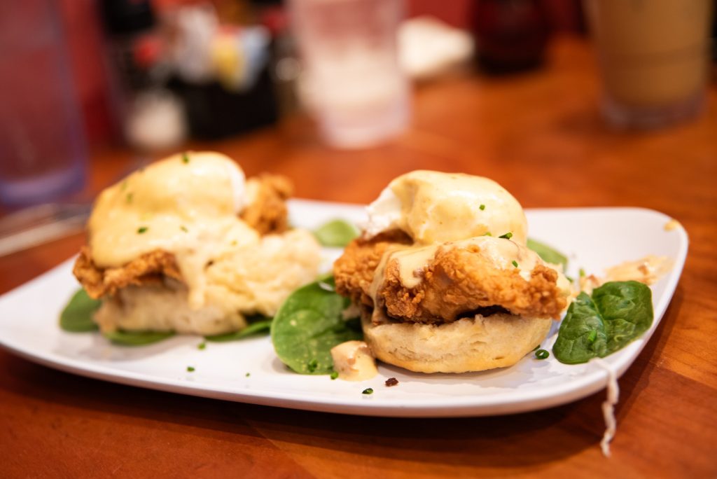 Chicken St. Charles with lightly battered fried chicken, biscuits, and a cheesy sauce. The dish featured doughy biscuits and overcooked eggs, with the sauce as a standout element