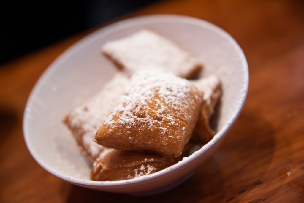 Candy apple beignets, served with cream cheese dip and sliced apples. A seasonal twist on the classic, featuring crispy, lightly sweet beignets topped with powdered sugar and whipped cream