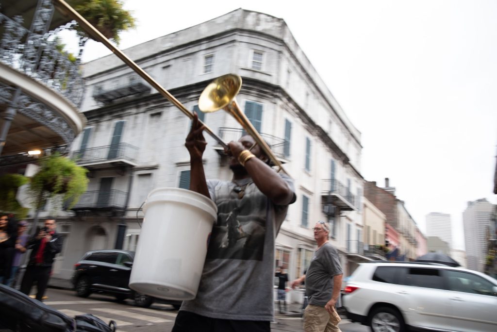 A trombonist blares on Bourbon Street while collecting cash from onlookers. No matter the hour, brass bands and lively music can be found on a stroll along the tourist catered Bourbon Street. Photographed by Finn Martin/BruinLife