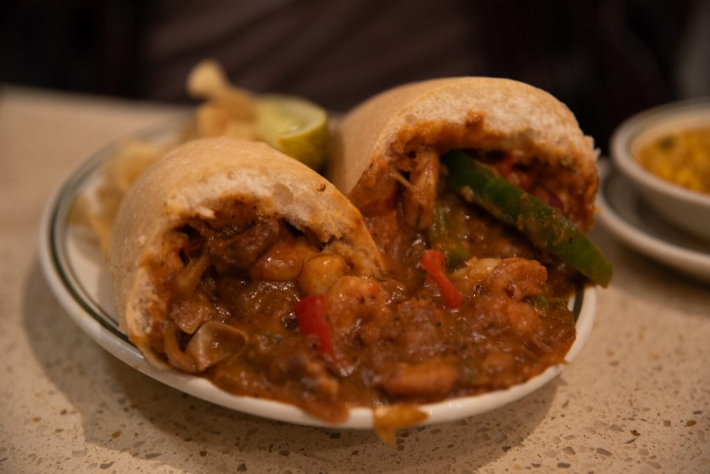 Living up to its name, the Gumbo Shop applies its gumbo specialize to its Po-Boy sandwiches.  Here is plated the Sautéed Shrimp Po-Boy.  Photographed by Finn Martin/BruinLife.