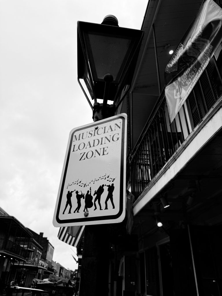 A street off of the iconic Bourbon Street, St. Peter Street in the French Quarter, designates specific loading zones for musicians to load their equipment into local establishments. Photographed by Cathryn Kuczynski/Bruinlife.