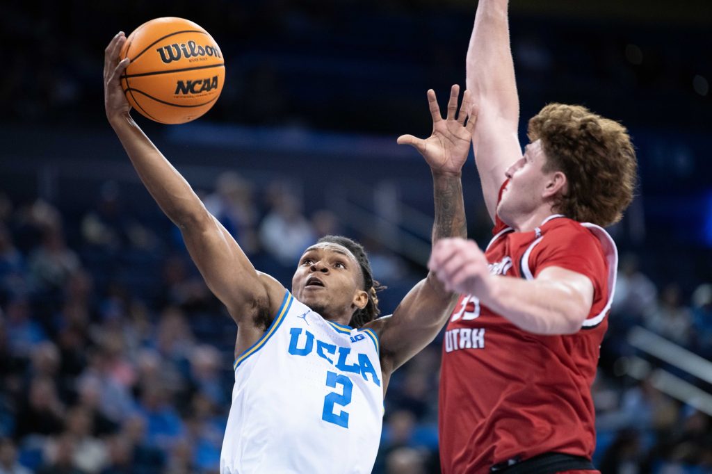 Dylan Andrews (#2) drives to the basket with determination, challenging Southern Utah's defense during an intense matchup at Pauley Pavilion.