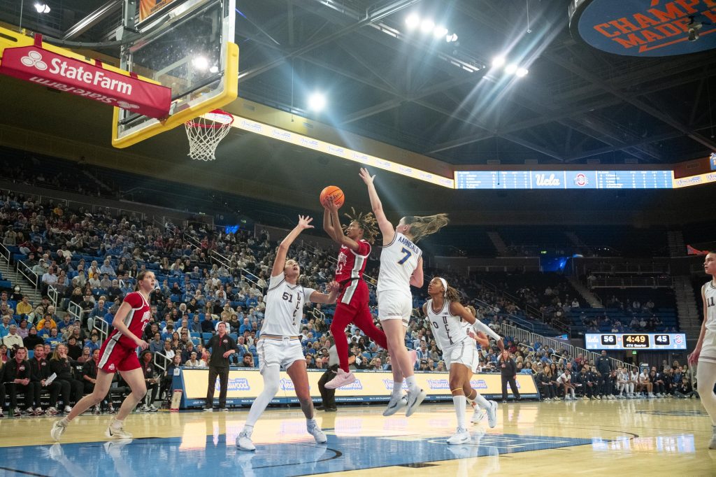 Ajae Petty weaves through the defense to attempt a layup over UCLA's defense. Photographed by Ryan Zhang/BruinLife.