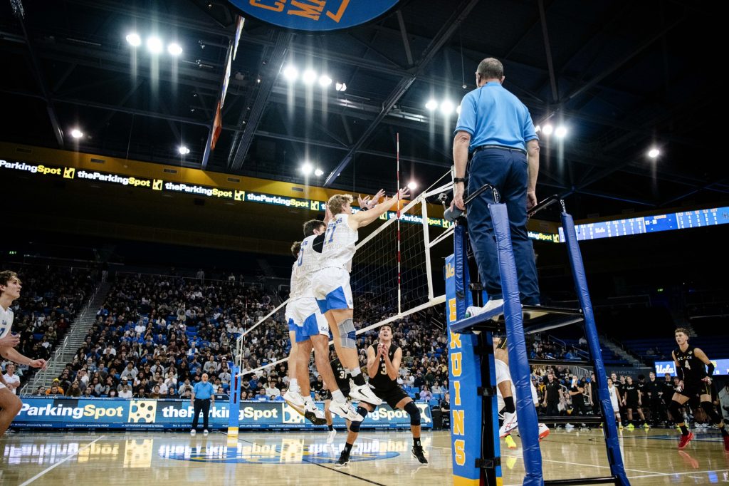 UCLA's Sean McQuiggan and Cooper Robinson jump high at the net to block Long Beach State's attack. Photographed by Ryan Zhang/BruinLife.