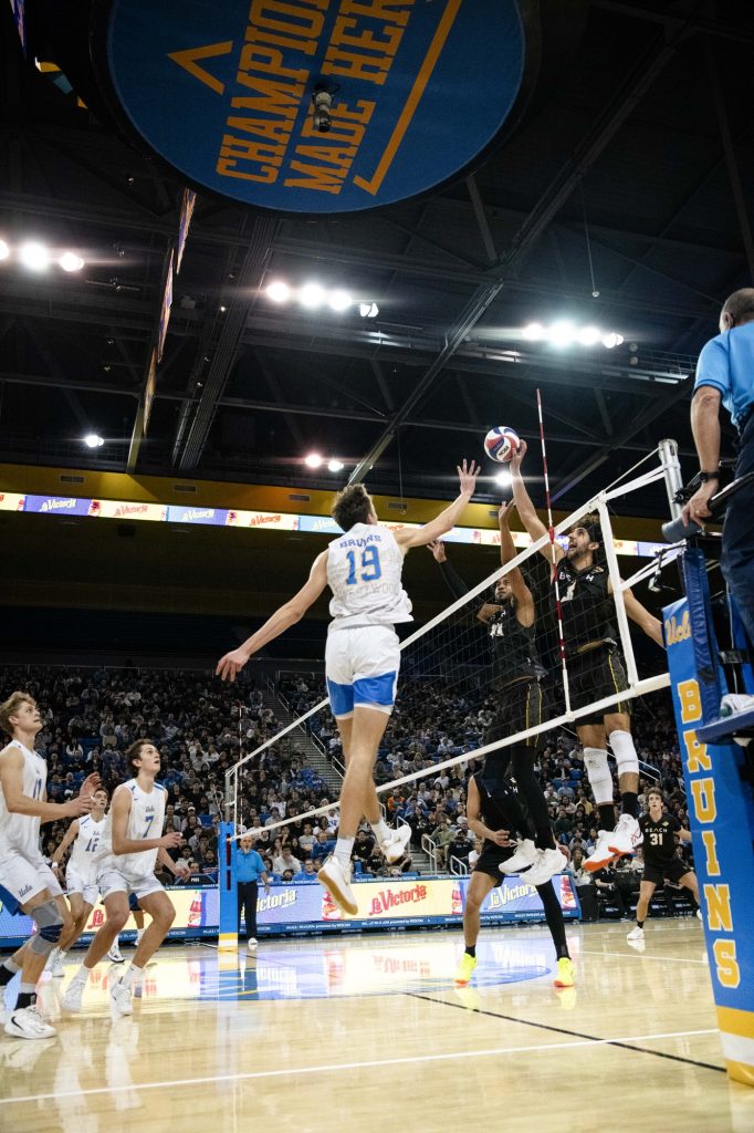 UCLA right side hitter #19 David Decker attempts to block Long Beach State's #8 Sotiris Siapanis'  tip over the net. Photographed by Ryan Zhang/BruinLife.