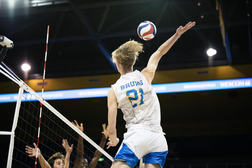 UCLA #21 Zach Rama, winds up and delivers a powerful strike over the outstretched blockers of UCSB. Photographed by Ryan Zhang/BruinLife