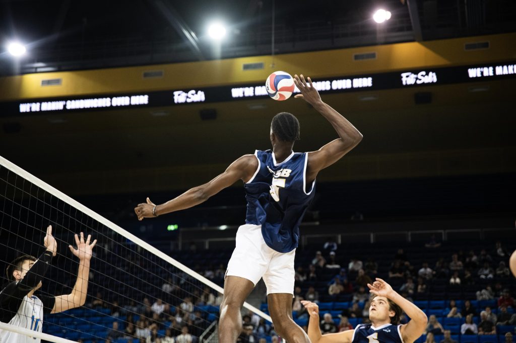 UCSB #16 Josh Aruya leaps high, ready to launch a powerful spike. Photographed by Ryan Zhang/BruinLife