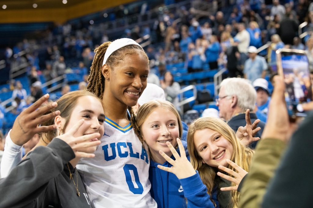 Janiah Barker takes pictures with fans, all showing a "fours up" sign