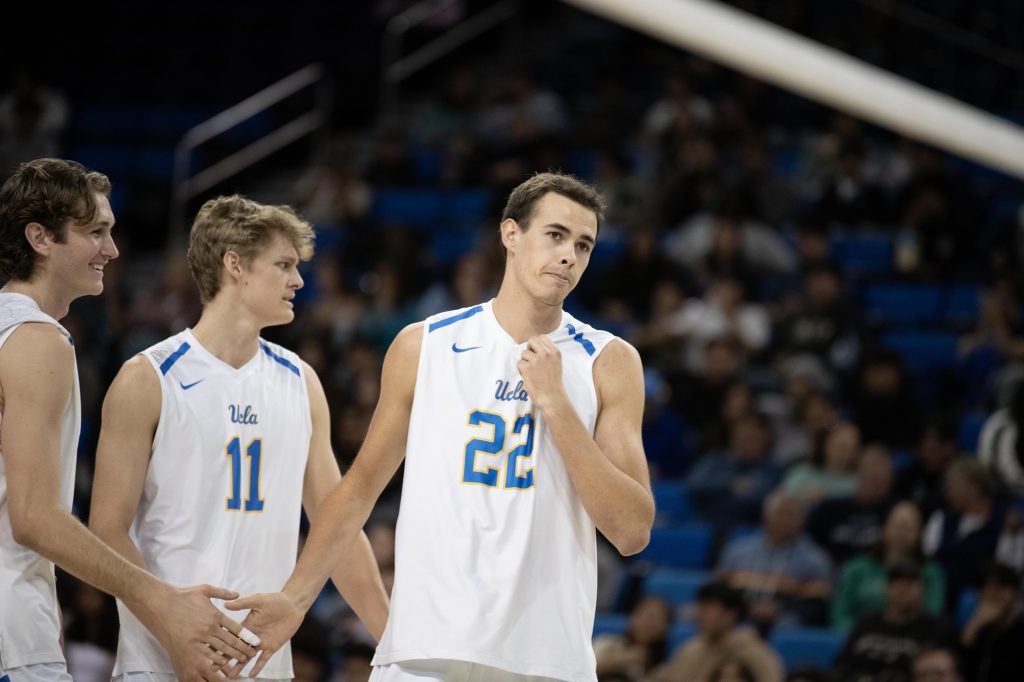 Matthew Edwards exchanges high-fives with teammates. The middle blocker brought in a crucial service ace in the first set. Photographed by Julia Gu/BruinLife.