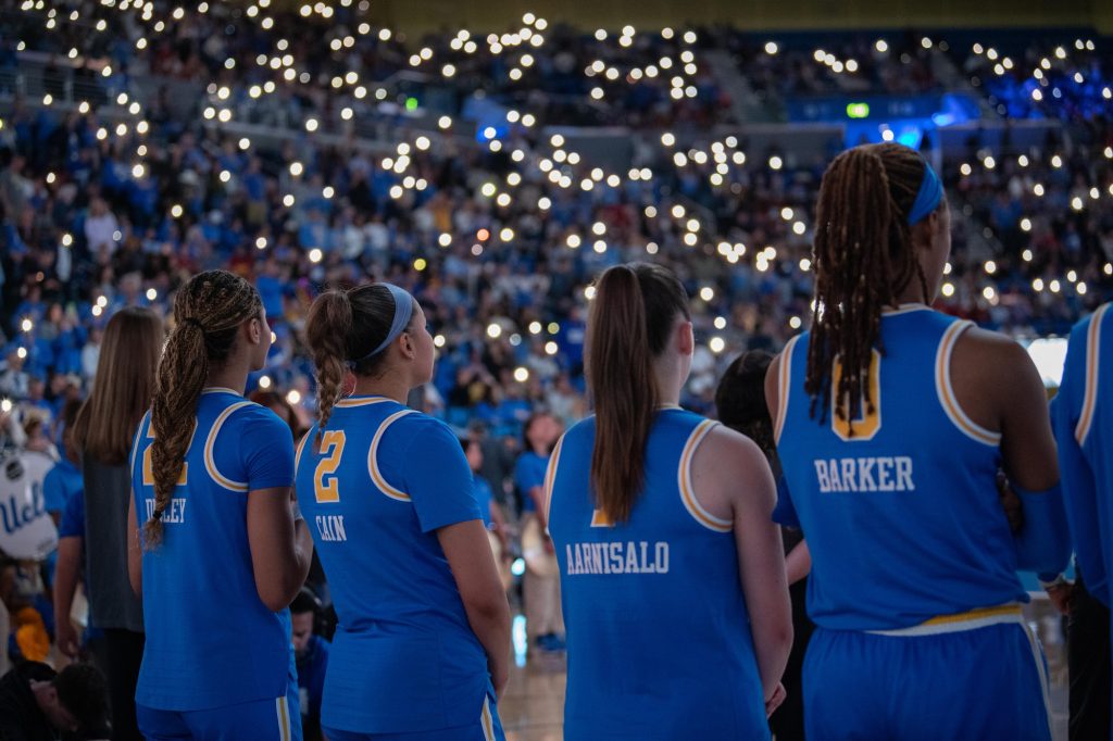 UCLA players line up side by side for the National Anthem, performed by UCLA's band.