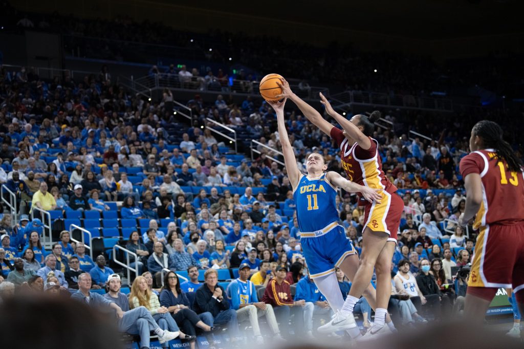 UCLA's #11 Gabriela Jaquez (left) attempts a layup as USC's Juju Watkins (right) blocks the shot.