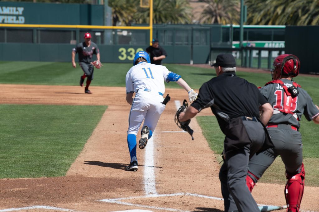 Payton Brennan runs to first after hitting the ball. The redshirt sophomore centerfielder contributed one hit and one run. Photographed by Catherine Rodriguez/BruinLife.