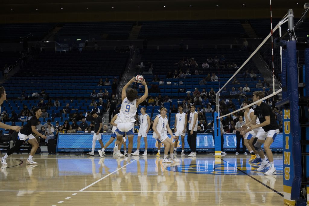 Trent Taliaferro sets the ball to his teammate during warmups before taking on Vanguard. The setter is a freshman at UCLA and made his debut as a Bruin earlier this season against Saint Francis. Photographed by Regan Rhodes/BruinLife