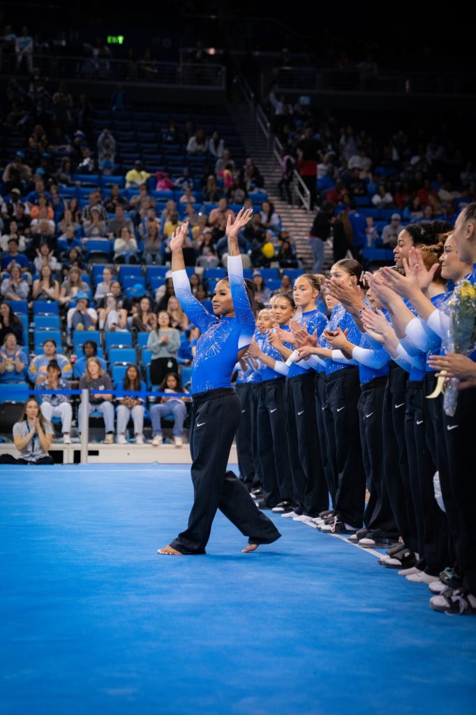 Jordan Chiles steps forward and waves to the crowd as her all-around victory is announced. Photographed by Cathryn Kuczynski/BruinLife.