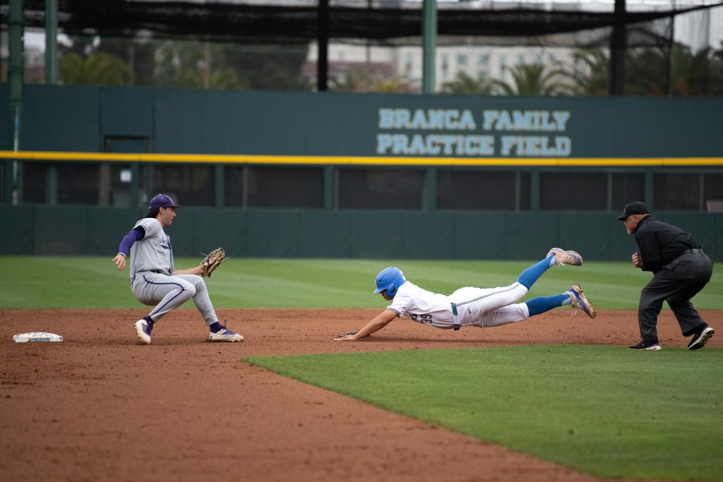 Mulivai Levu dives headfirst into second base, beating the tag. Photographed by Maia Salti/BruinLife Photographed by Maia Salti/BruinLife