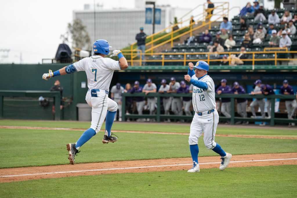 Roman Martin (left) shares a mid-run fist bump with assistant coach Niko Gallego (right) on his way back to home plate after launching a home run. Photographed by Maia Salti/BruinLife Photographed by Maia Salti/BruinLife
