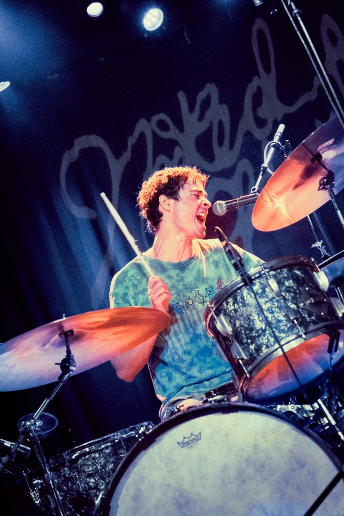 LaVallee, fully immersed in the moment, brings his energy to the drums while adding his voice to the performance. Photographed by Amy Miranda/BruinLife.