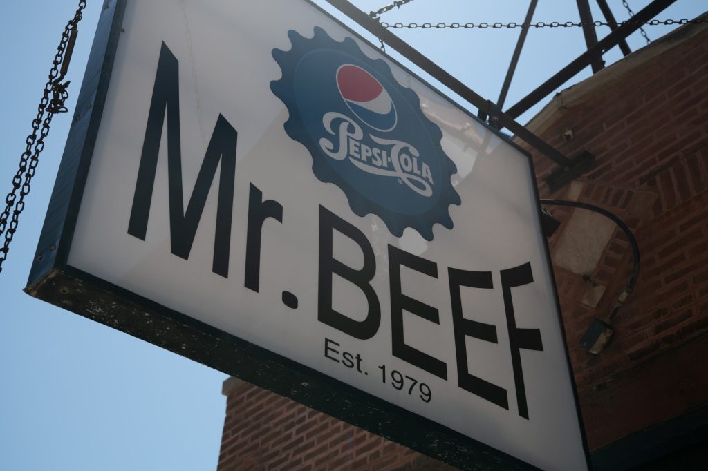 The sign for Mr. Beef&squot;s hangs high above the deli&squot;s entrance. Established in 1979, this shop draws in customers with its authentic food and appearance in the series "The Bear." Photographed by Finn Martin/BruinLife.
