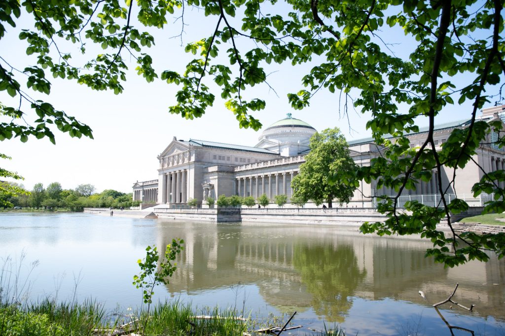 The Chicago Museum of Science and Industry seen over the lagoon in Jackson Park. Photographed by Finn Martin/BruinLife.