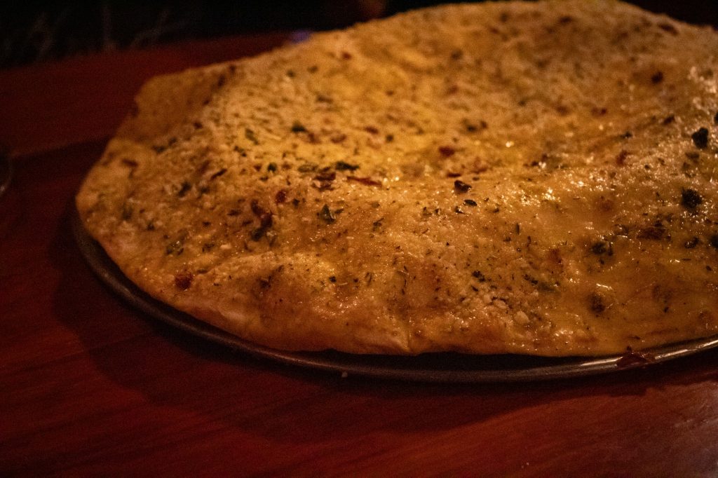 The Mediterranean Bread brings an epicurean bite reminiscent of naan and roti, but seasoned healthily with sun dried tomatoes, garlic and parmesan cheese. The bread overflowed from a beautiful ceramic bowl (buried beneath the ample helping shown in the photo). Photographed by Finn Martin/BruinLife.