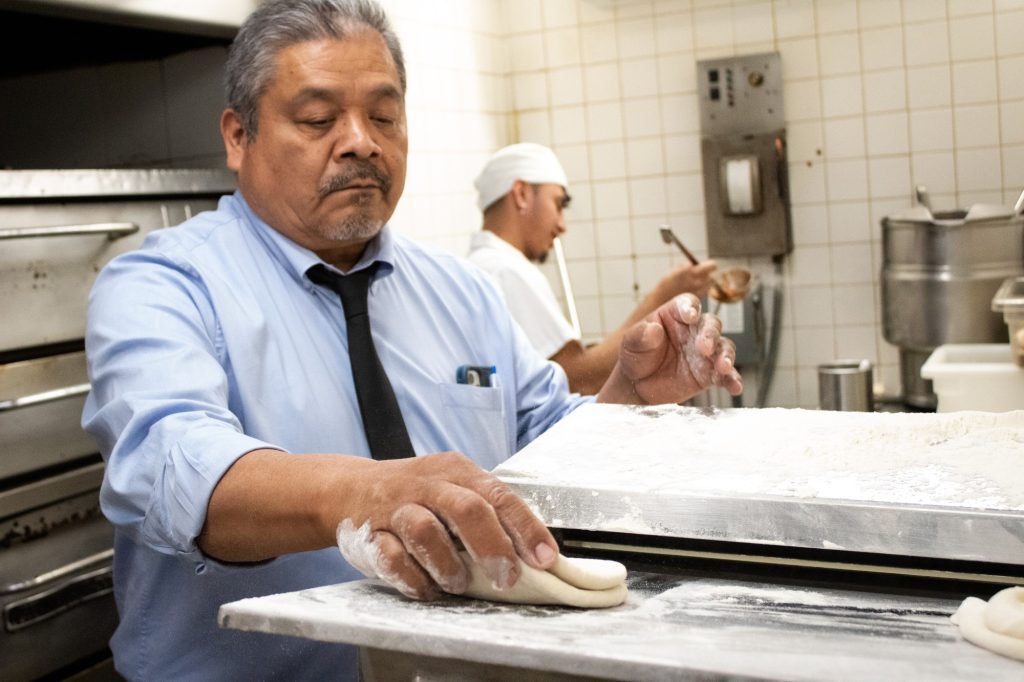 Manager Mariano takes us back into the kitchen where he demonstrates the process each meal is made freshly with daily. Here, he prepared dough for the Pizza Pot Pie. Photographed by Finn Martin/BruinLife.