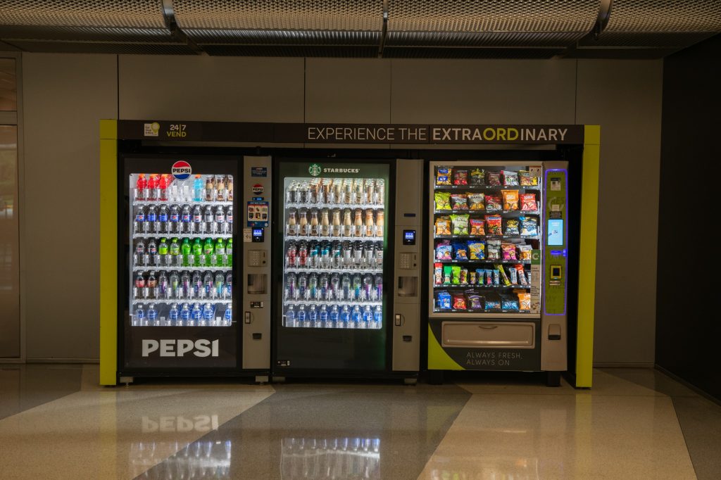 One of the three views permitted by the baggage claim benches. These vending machines compete fiercely with Hudson News, but have forfeited the sale of Skittles to its down claim rival. Photographed by Finn Martin/BruinLife.